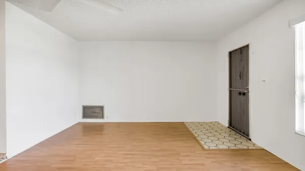 a view of an empty room and kitchen