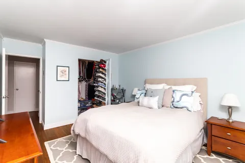 a bedroom with a bed and wooden floor