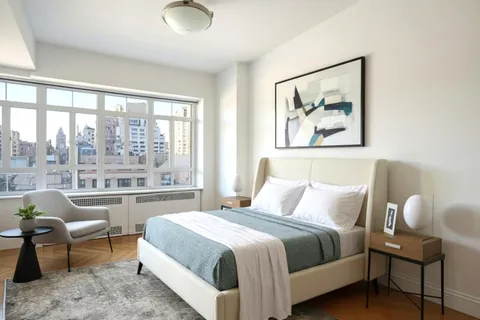 a bedroom with a bed and a large window