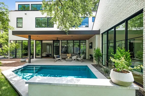 a view of a house with backyard swimming pool and sitting area