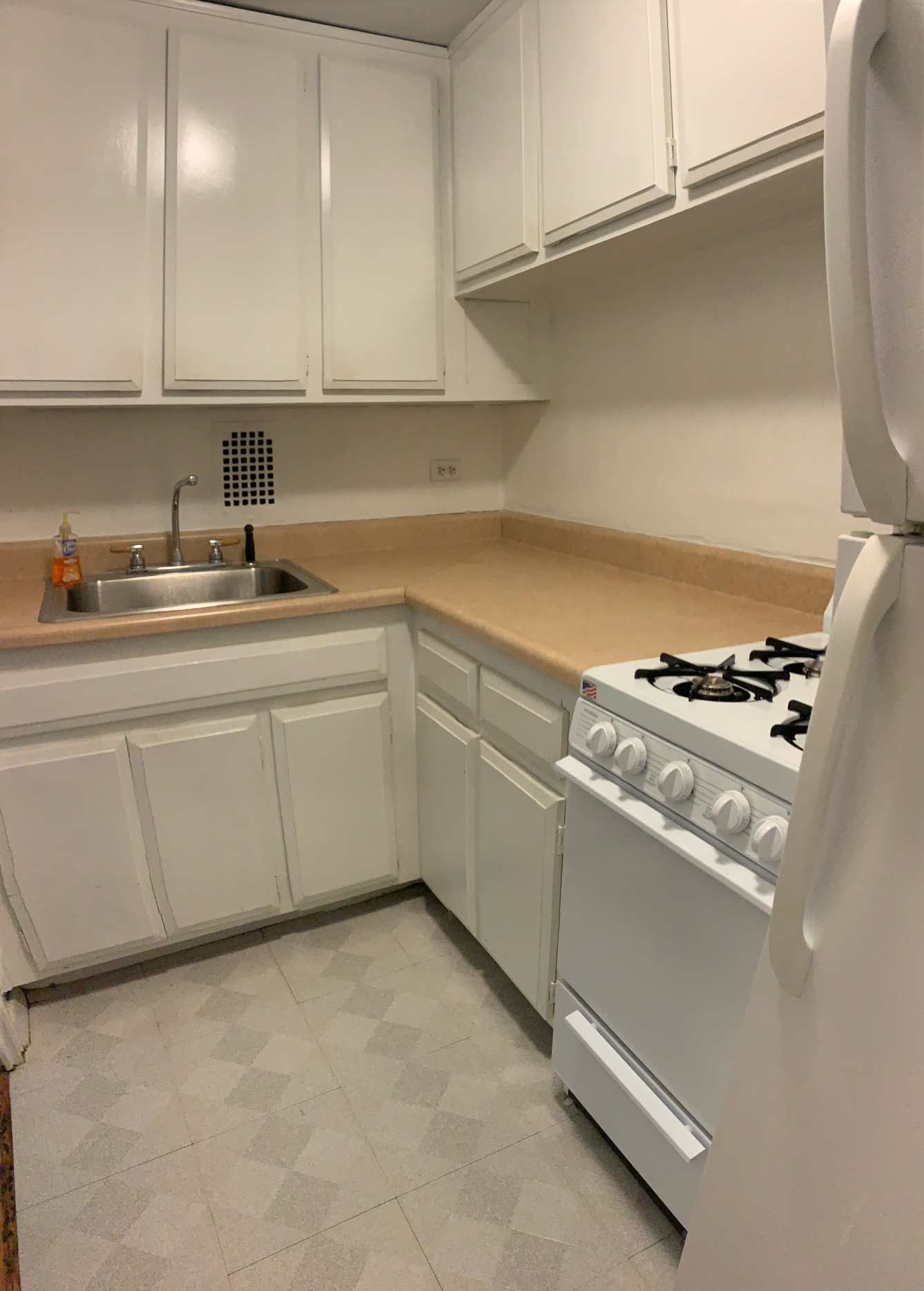 220 East 57th Street, Unit 12E Manhattan, NY 10022 - Photo 3 of 8 a kitchen with stainless steel appliances a sink stove and cabinets