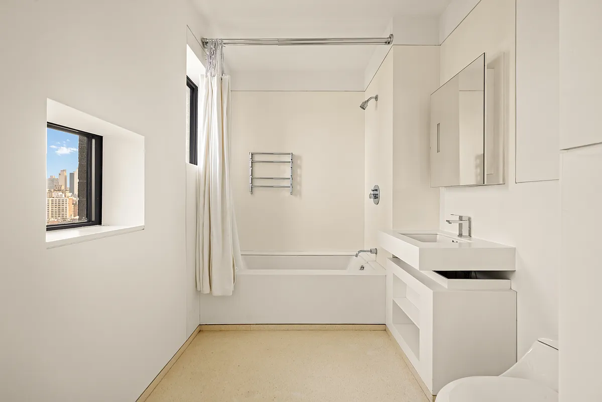 100 11th Avenue, Unit 16A Manhattan, NY 10011 - Photo 12 of 17 a bathroom with a bathtub and a shower