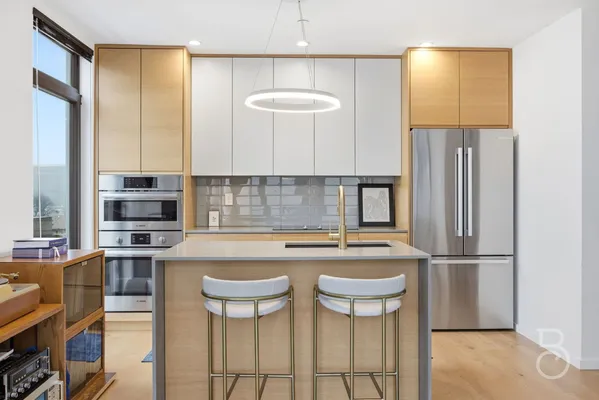 a kitchen with stainless steel appliances granite countertop a stove a refrigerator and a dining table