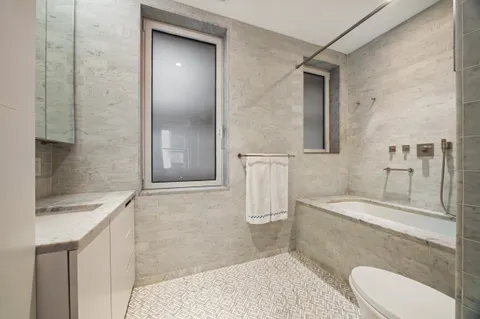 a bathroom with a sink a toilet and shower