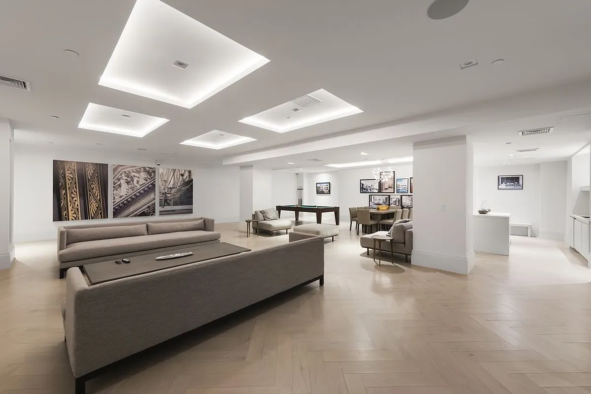 101 Wall Street, Unit 17A Manhattan, NY 10005 - Photo 11 of 13 a view of a living room and kitchen with furniture and a ceiling fan