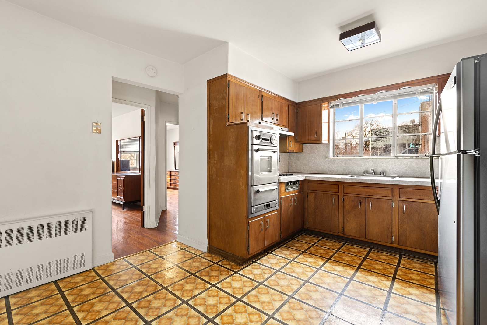 612 17th Street Brooklyn, NY 11218 - Photo 3 of 12 a kitchen with a refrigerator sink and cabinets