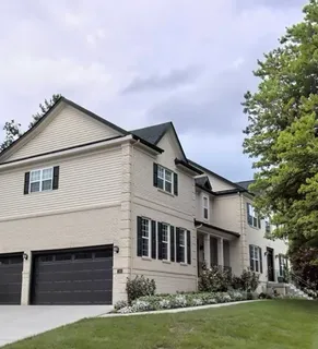 a front view of a house with a garden and yard