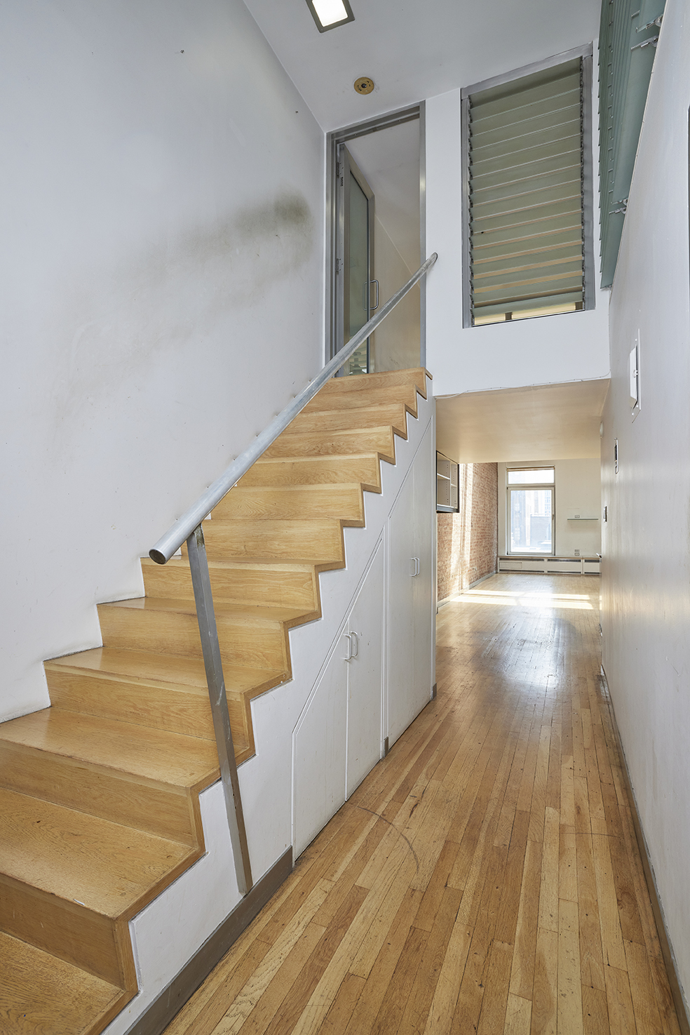 250 Mercer Street, Unit C603 Manhattan, NY 10012 - Photo 6 of 10 a view of entryway and kitchen with wooden floor
