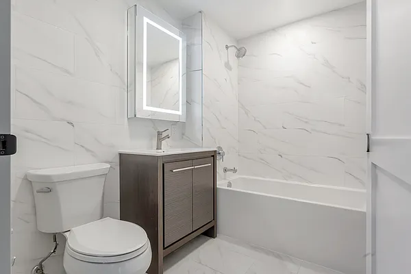 605 Hart Street, Unit 406 Brooklyn, NY 11221 - Photo 4 of 10 a bathroom with a sink a toilet and shower