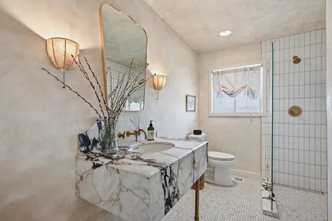 a bathroom with a sink toilet and shower