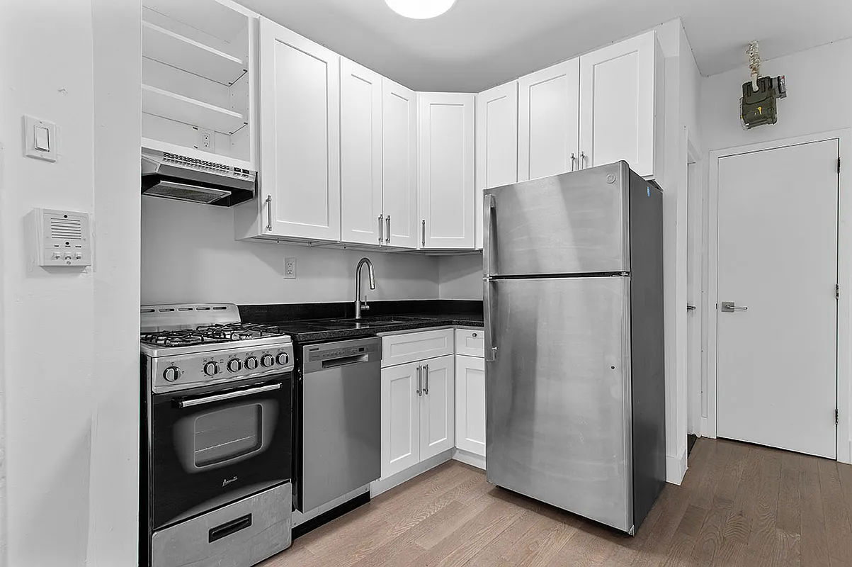 112 East 4th Street, Unit 6 Manhattan, NY 10003 - Photo 2 of 5 a kitchen with stainless steel appliances white cabinets and a refrigerator