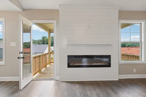 a view of a livingroom with wooden floor and a fireplace