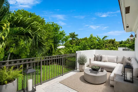 a view of a balcony with two chairs and a potted plant