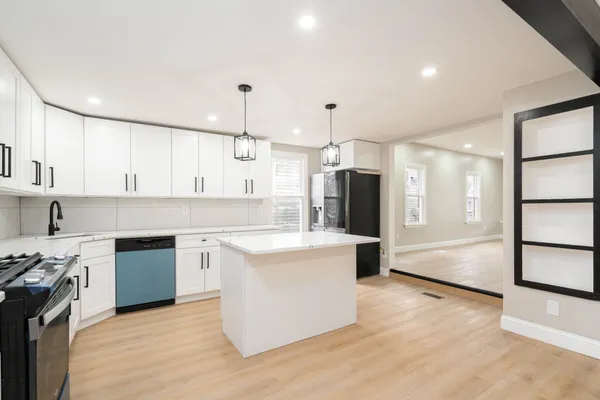 a large kitchen with stainless steel appliances granite countertop a stove and a refrigerator