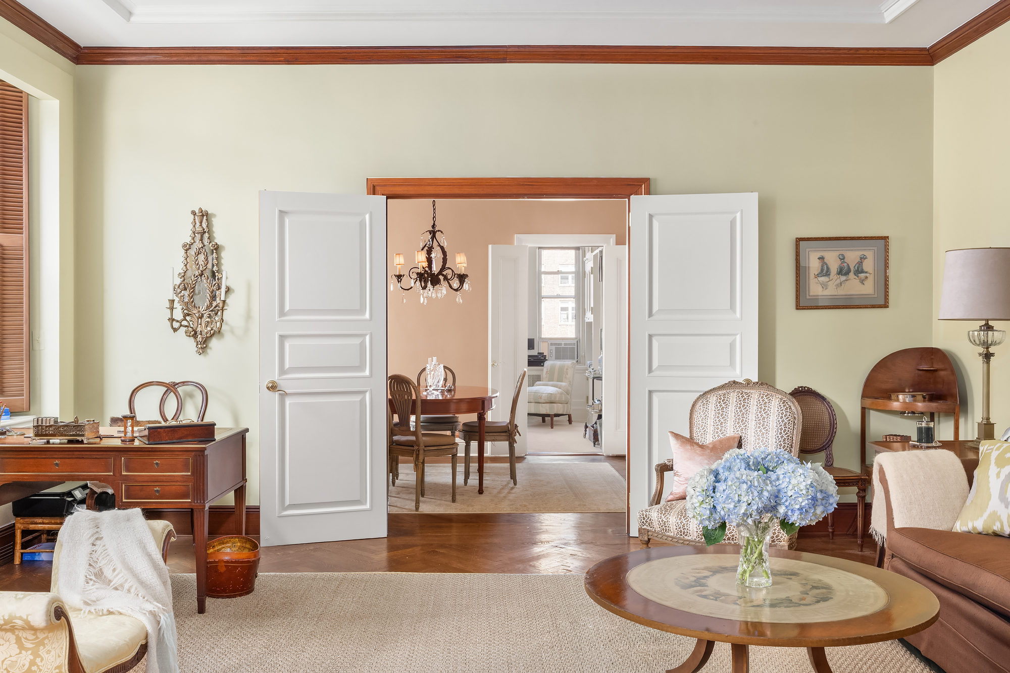 31 East 72nd Street, Unit 7B Manhattan, NY 10021 - Photo 7 of 13 a living room with furniture a dining table and a chandelier