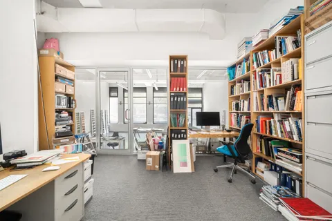 a view of a workspace with furniture and a book shelf