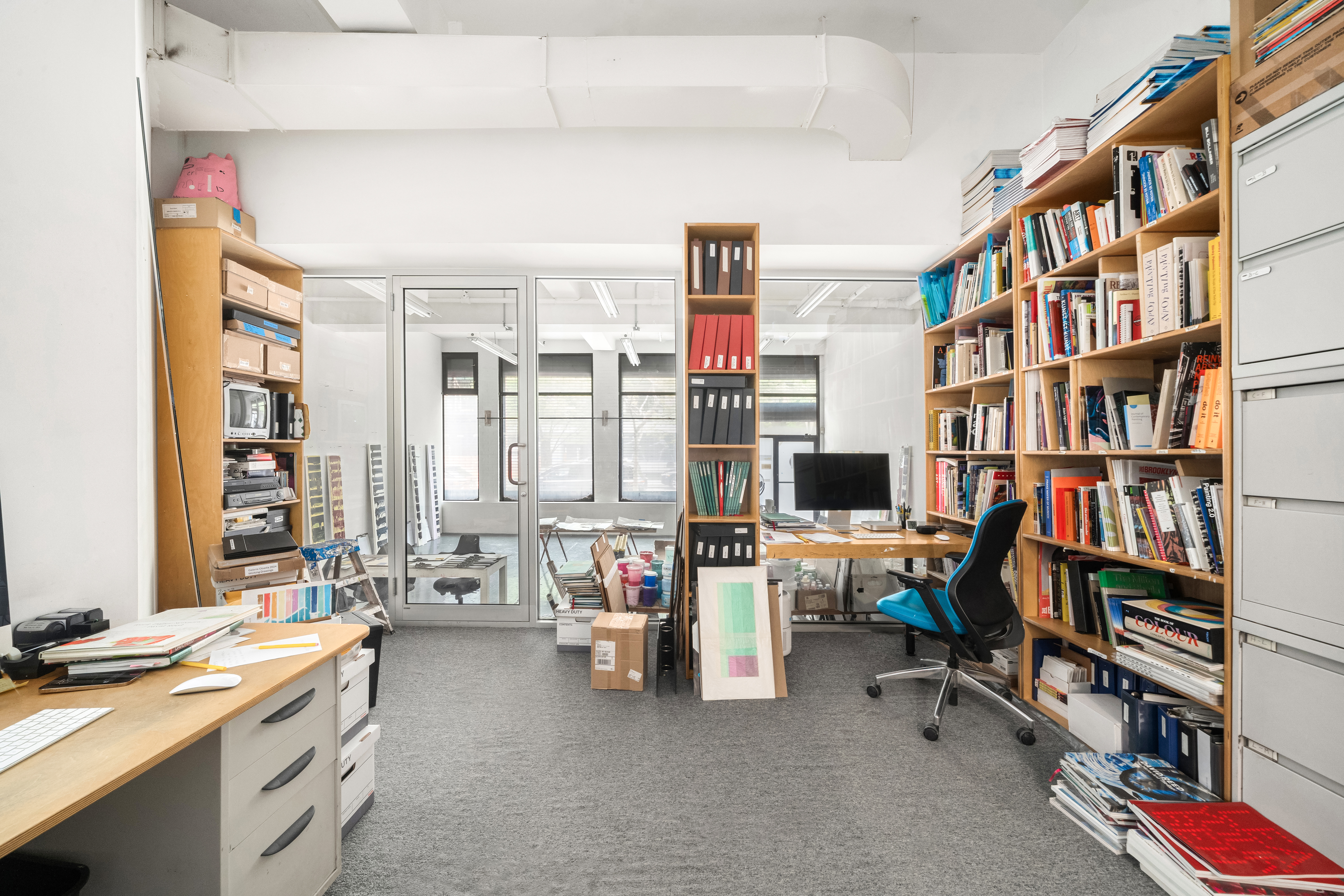 506 Greenwich Street, Unit 104 Manhattan, NY 10013 - Photo 4 of 9 a view of a workspace with furniture and a book shelf