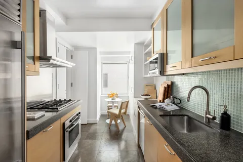 a kitchen with stainless steel appliances granite countertop a sink stove and cabinets