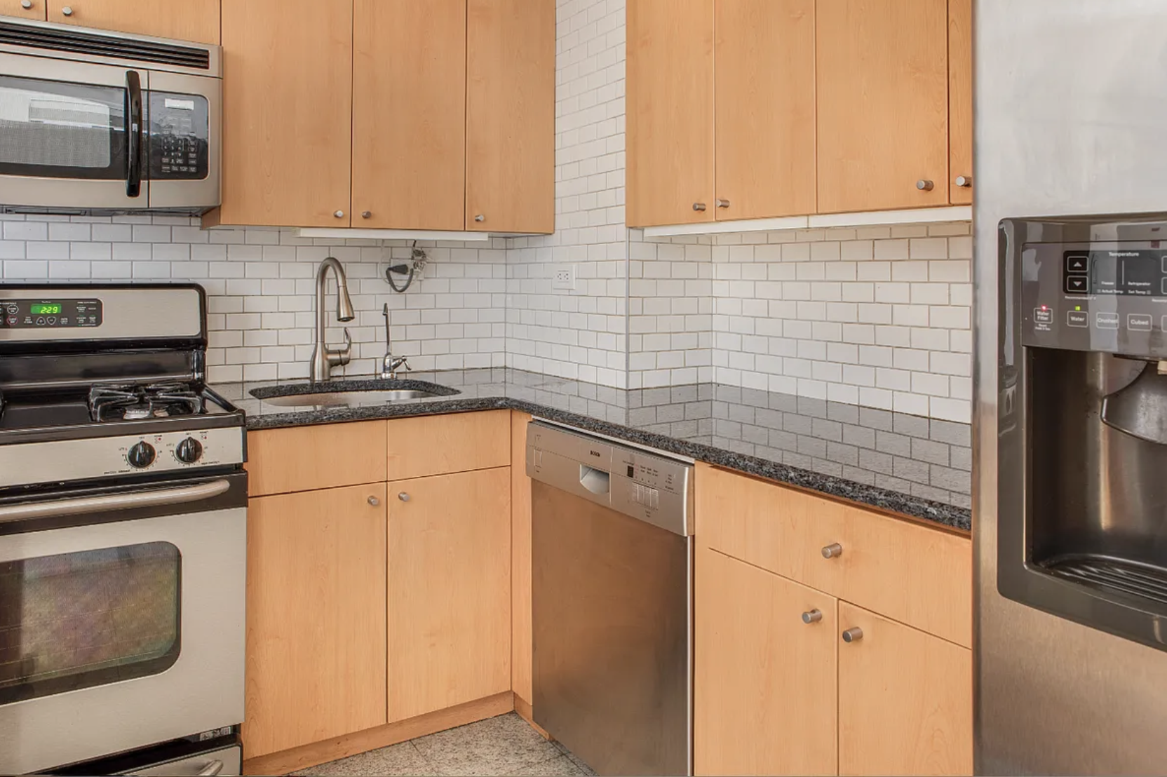 420 East 64th Street, Unit E7K Manhattan, NY 10065 - Photo 4 of 10 a kitchen with stainless steel appliances granite countertop a sink stove and refrigerator