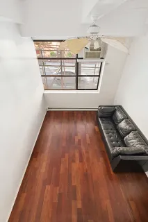 a view of a room with wooden floor water heater and windows