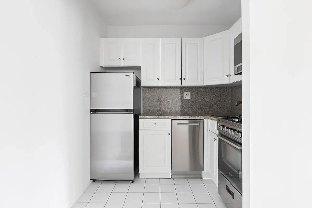 a kitchen with a refrigerator sink and cabinets