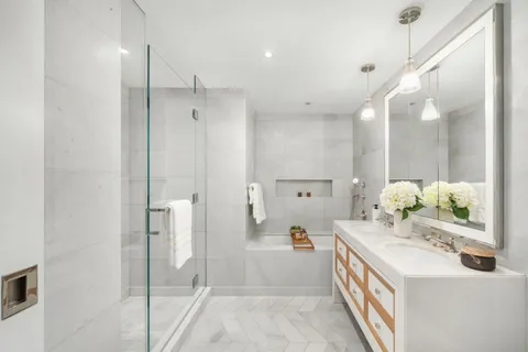 a bathroom with a double vanity sink mirror and shower