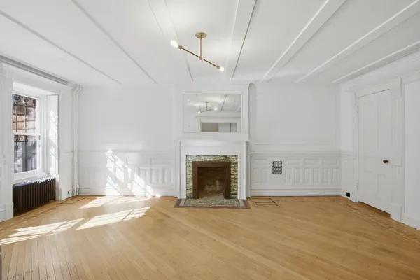 a view of empty room with fireplace and windows