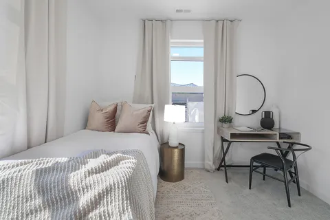 a bedroom with a bed a desk and chair