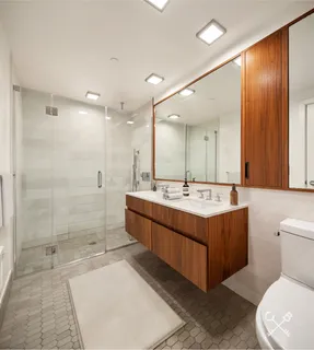 a bathroom with a double vanity sink toilet and shower