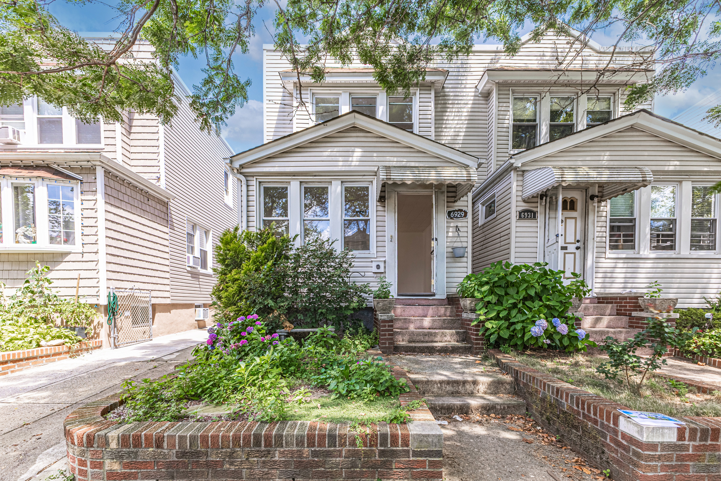 69-29 67th Place Queens, NY 11385 - Photo 2 of 24 a front view of a house with garden
