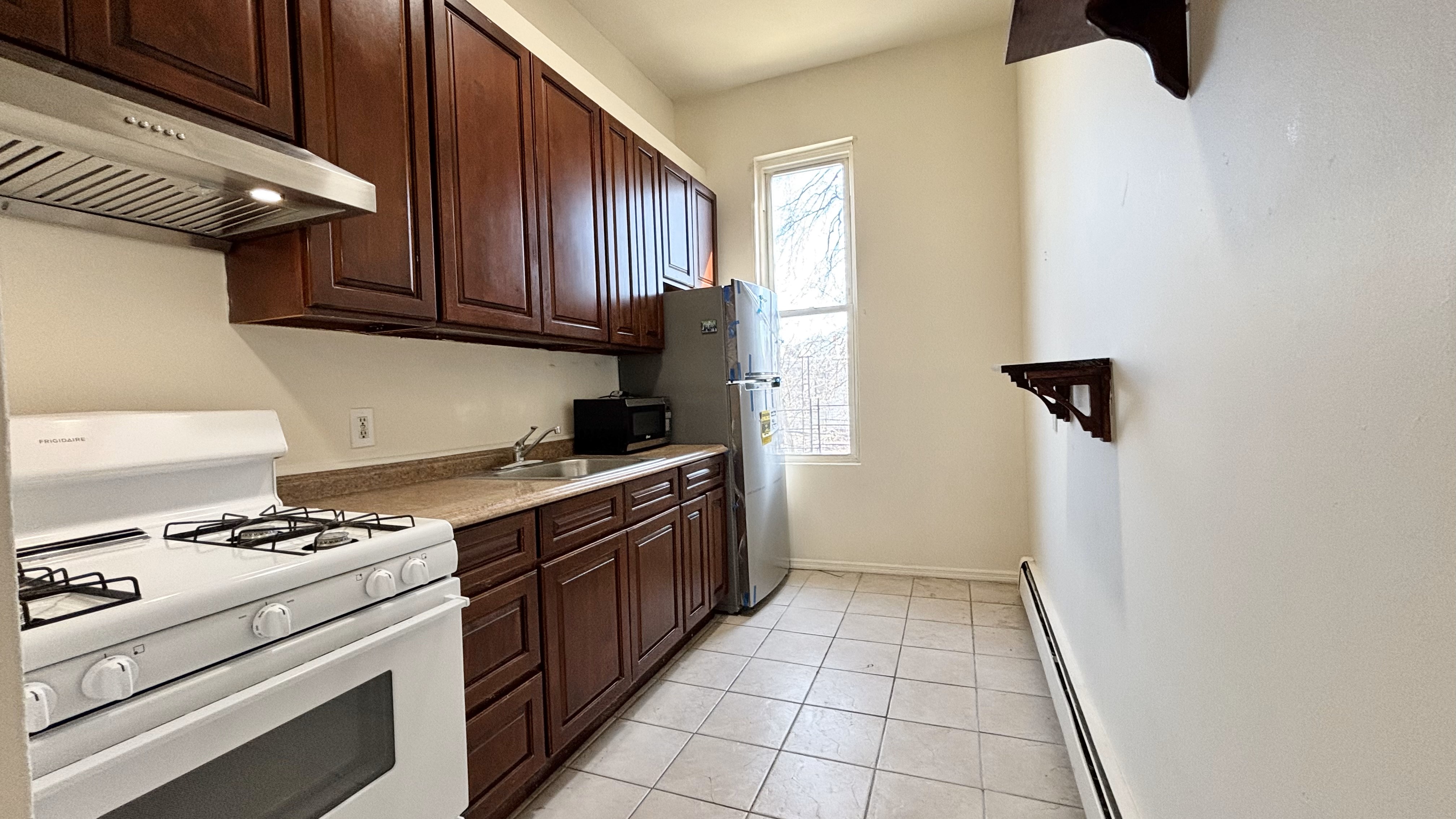 74 Himrod Street, Unit 2 Brooklyn, NY 11221 - Photo 13 of 16 a kitchen with a stove and a refrigerator