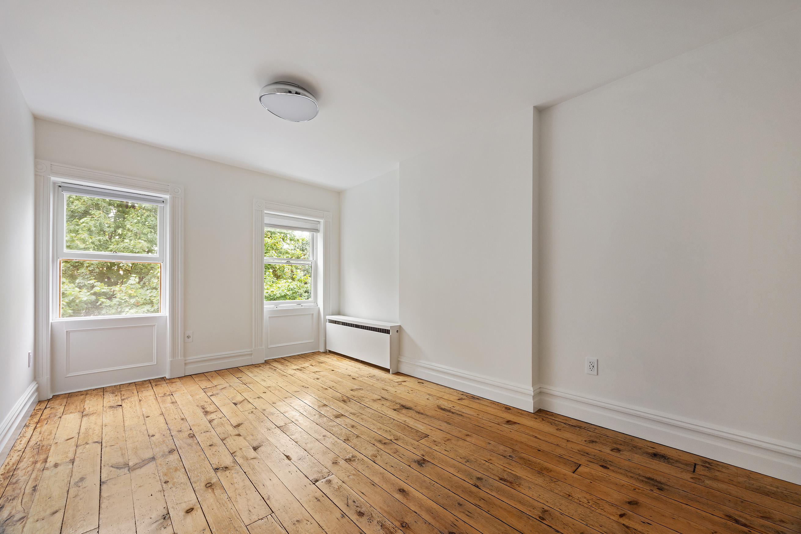 64 Clifton Place, Unit 2 Brooklyn, NY 11238 - Photo 12 of 16 an empty room with wooden floor and windows