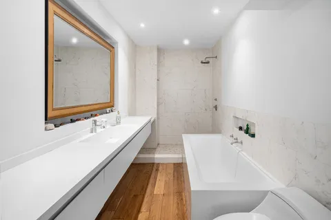 a bathroom with a bathtub and double vanity