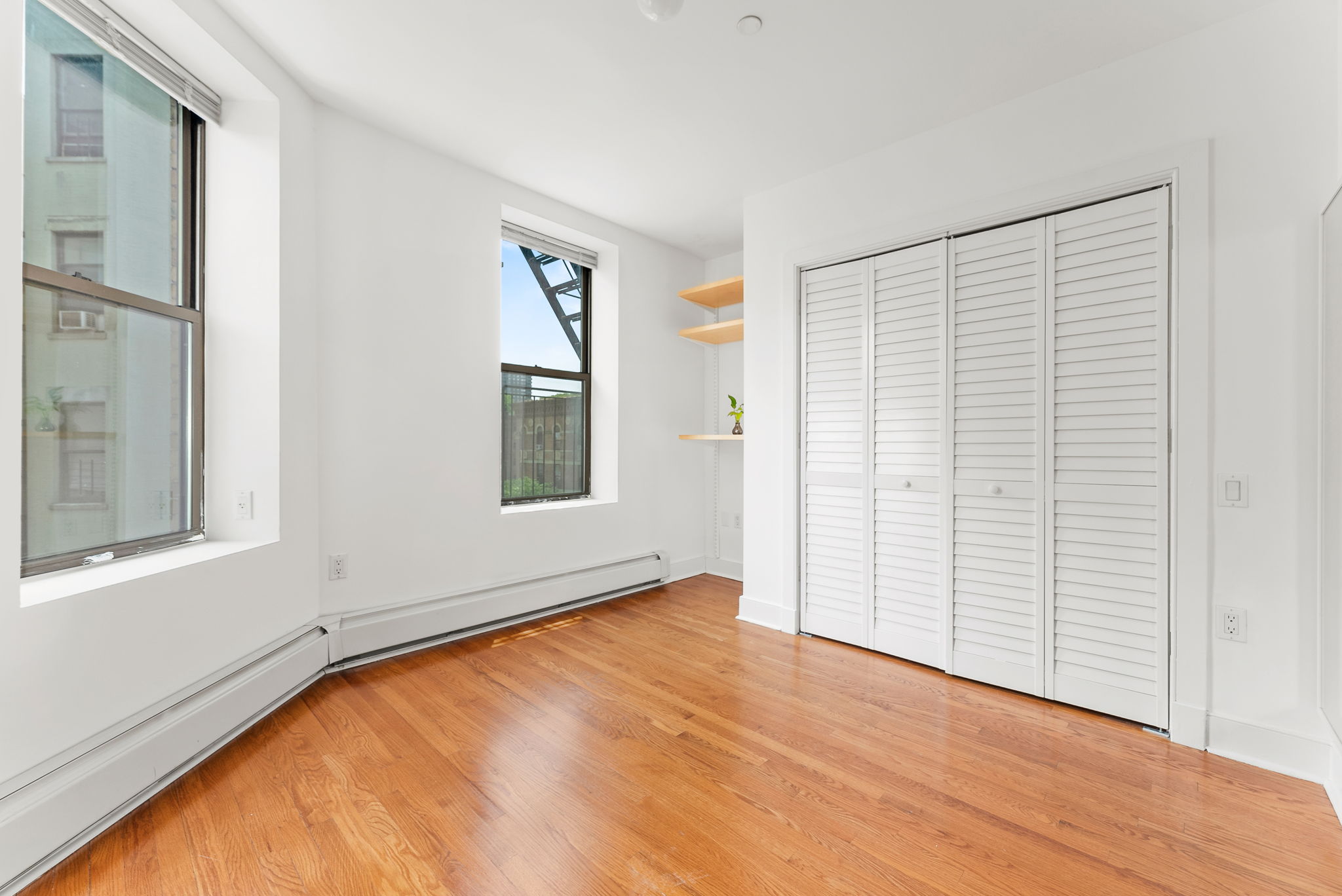 305 West 150th Street, Unit 511 Manhattan, NY 10039 - Photo 8 of 17 an empty room with wooden floor and windows