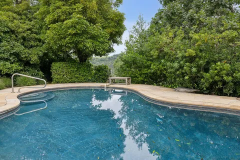 an aerial view of a house with yard and swimming pool