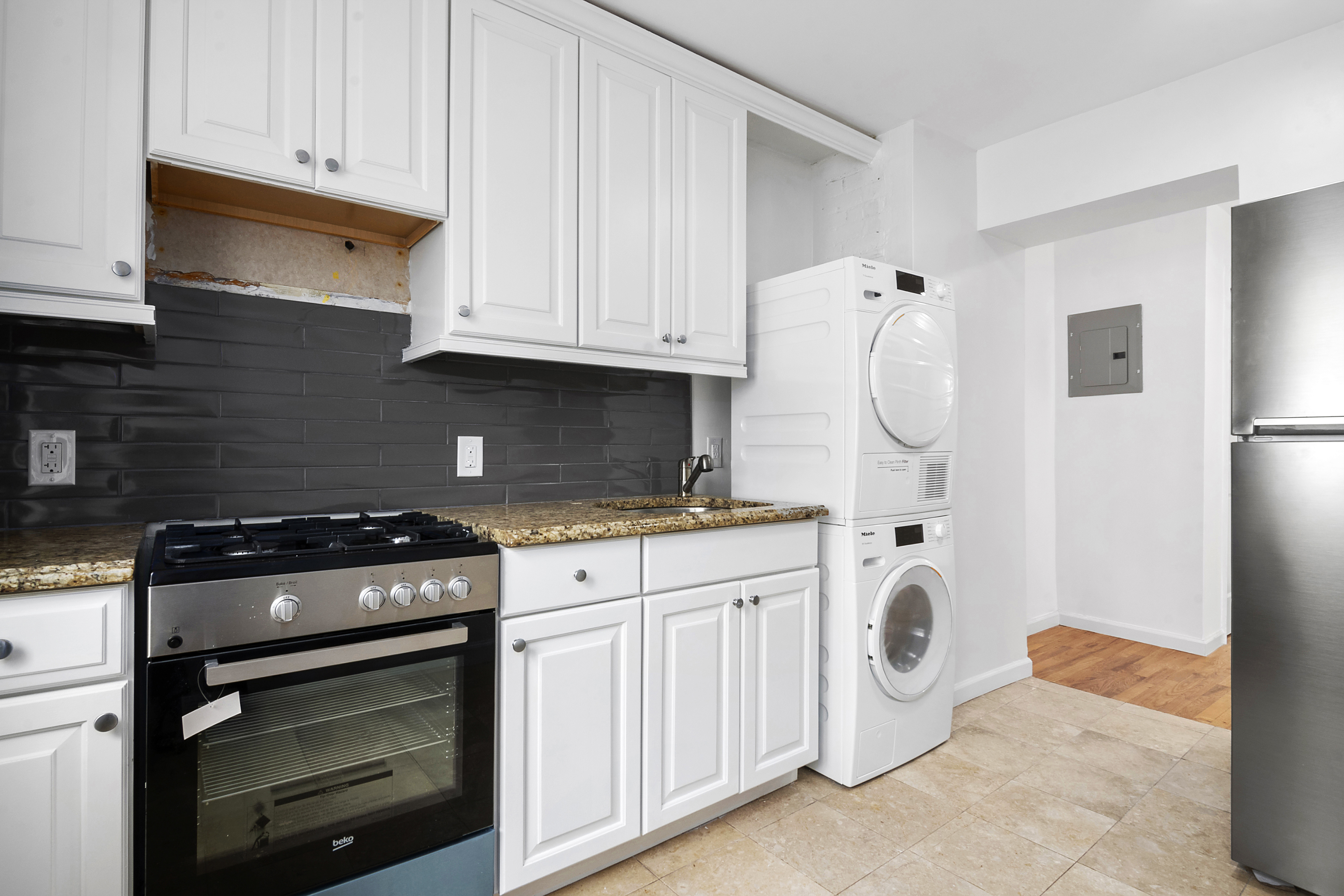 224 Hall Street Brooklyn, NY 11205 - Photo 5 of 7 a kitchen with granite countertop a stove a washer and dryer
