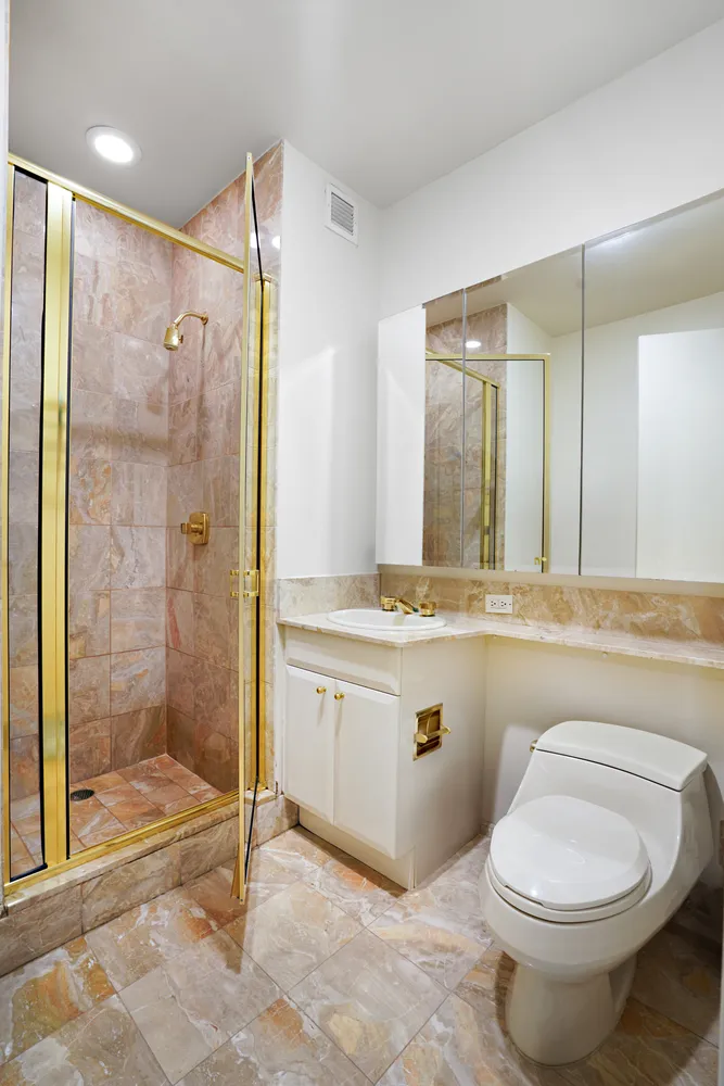 a bathroom with a granite countertop sink toilet and shower