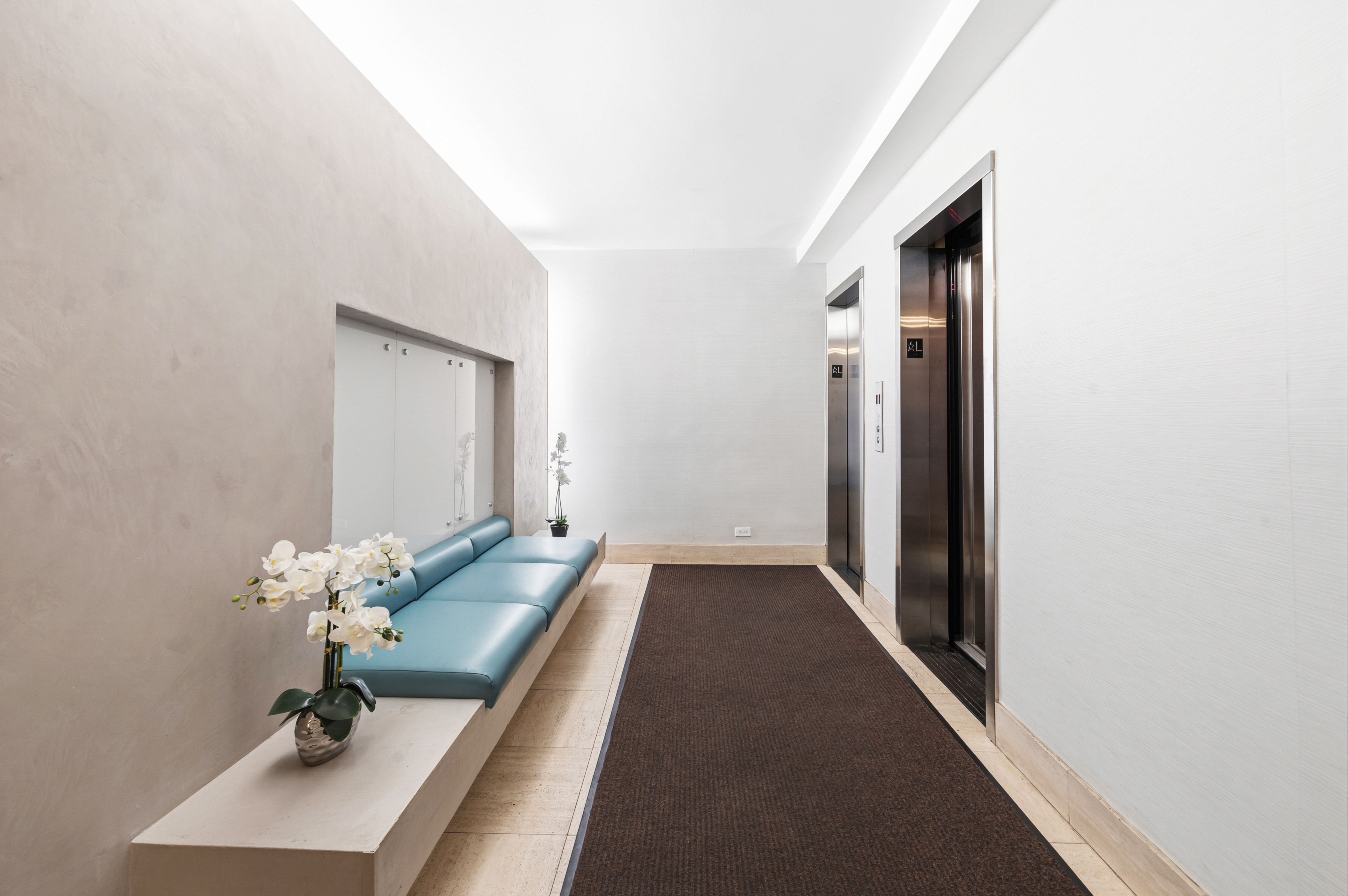 166 East 35th Street, Unit 5C Manhattan, NY 10016 - Photo 11 of 16 a hallway with mirror and flowers