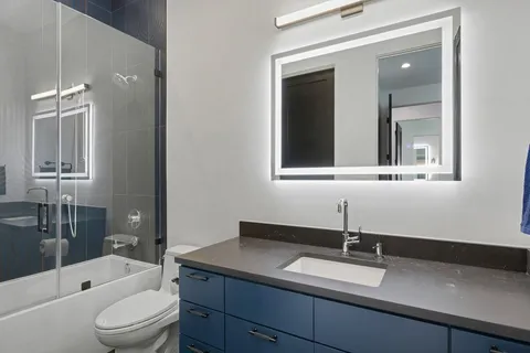 a bathroom with a granite countertop sink toilet and shower