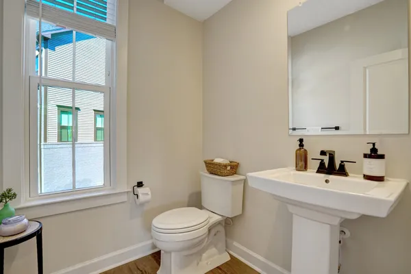 a bathroom with a sink a toilet and a window