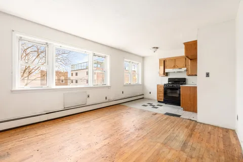 a view of a kitchen with wooden floor electronic appliances and windows