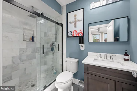 a bathroom with a sink a toilet and shower