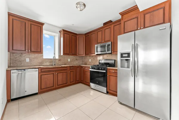 a kitchen with stainless steel appliances granite countertop a refrigerator a stove a sink and dishwasher