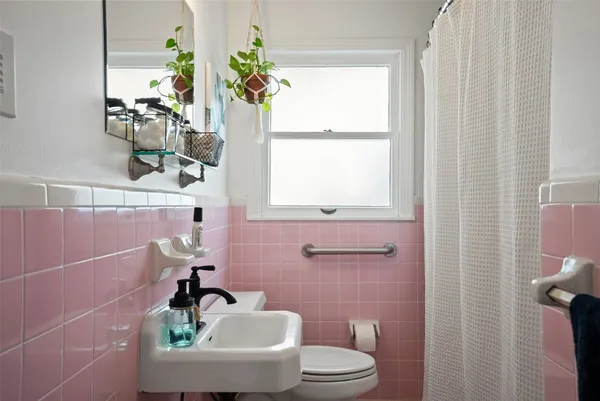 a bathroom with a sink a toilet and a window