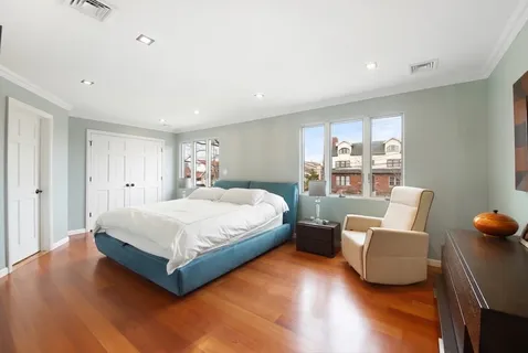 a spacious bedroom with a bed and wooden floor