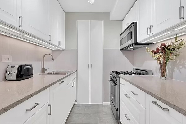 343 East 74th Street, Unit 14K Manhattan, NY 10021 - Photo 4 of 7 a kitchen with stainless steel appliances granite countertop white cabinets and a sink