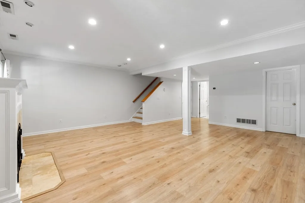 an empty room with wooden floor and entryway
