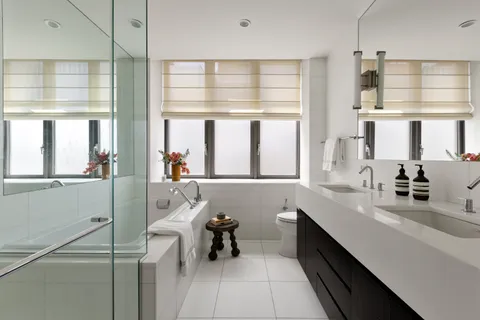 a bathroom with a sink a mirror and next to a window