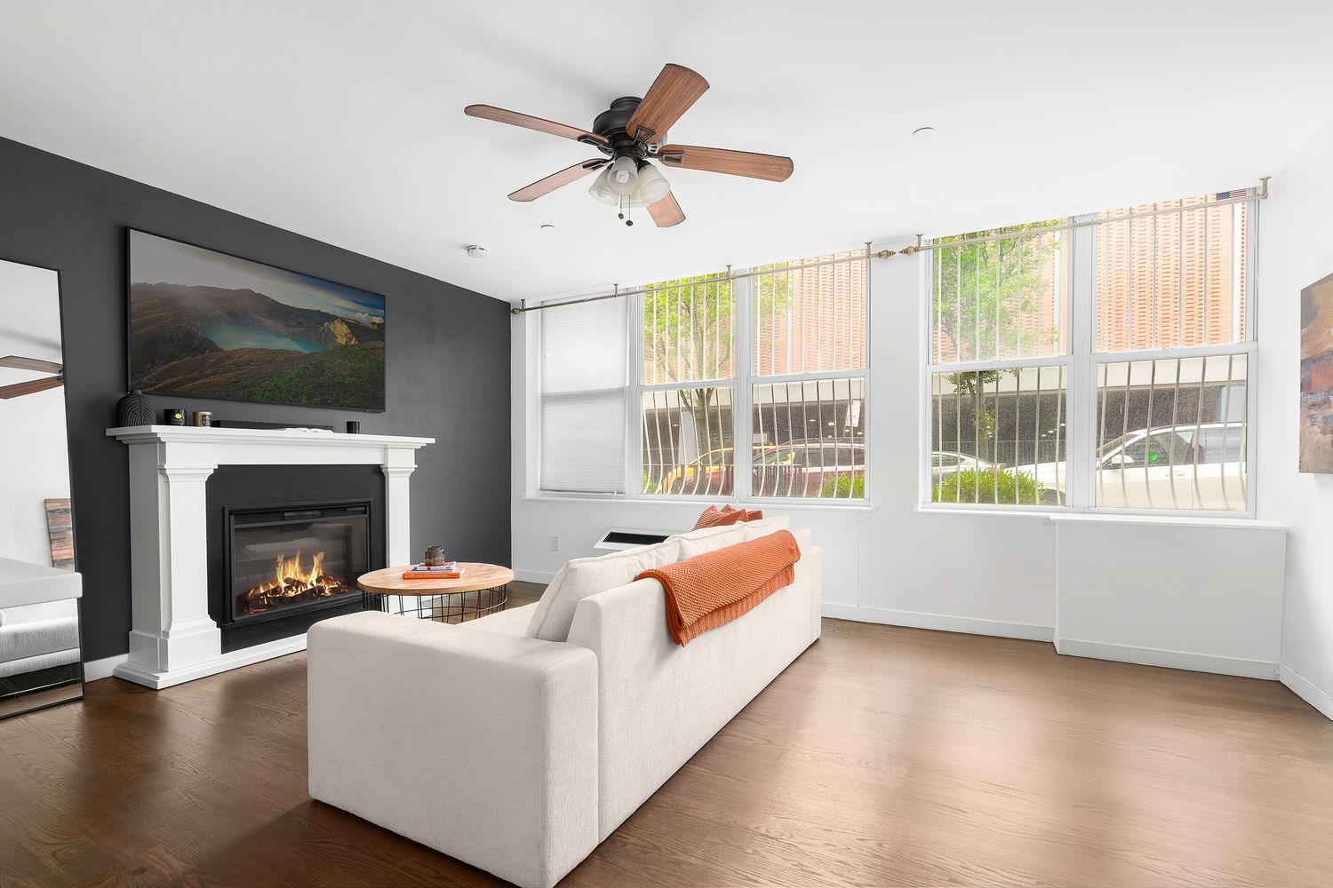 51 East 128th Street, Unit 1C Manhattan, NY 10035 - Photo 3 of 9 a living room with furniture a flat screen tv and a fireplace