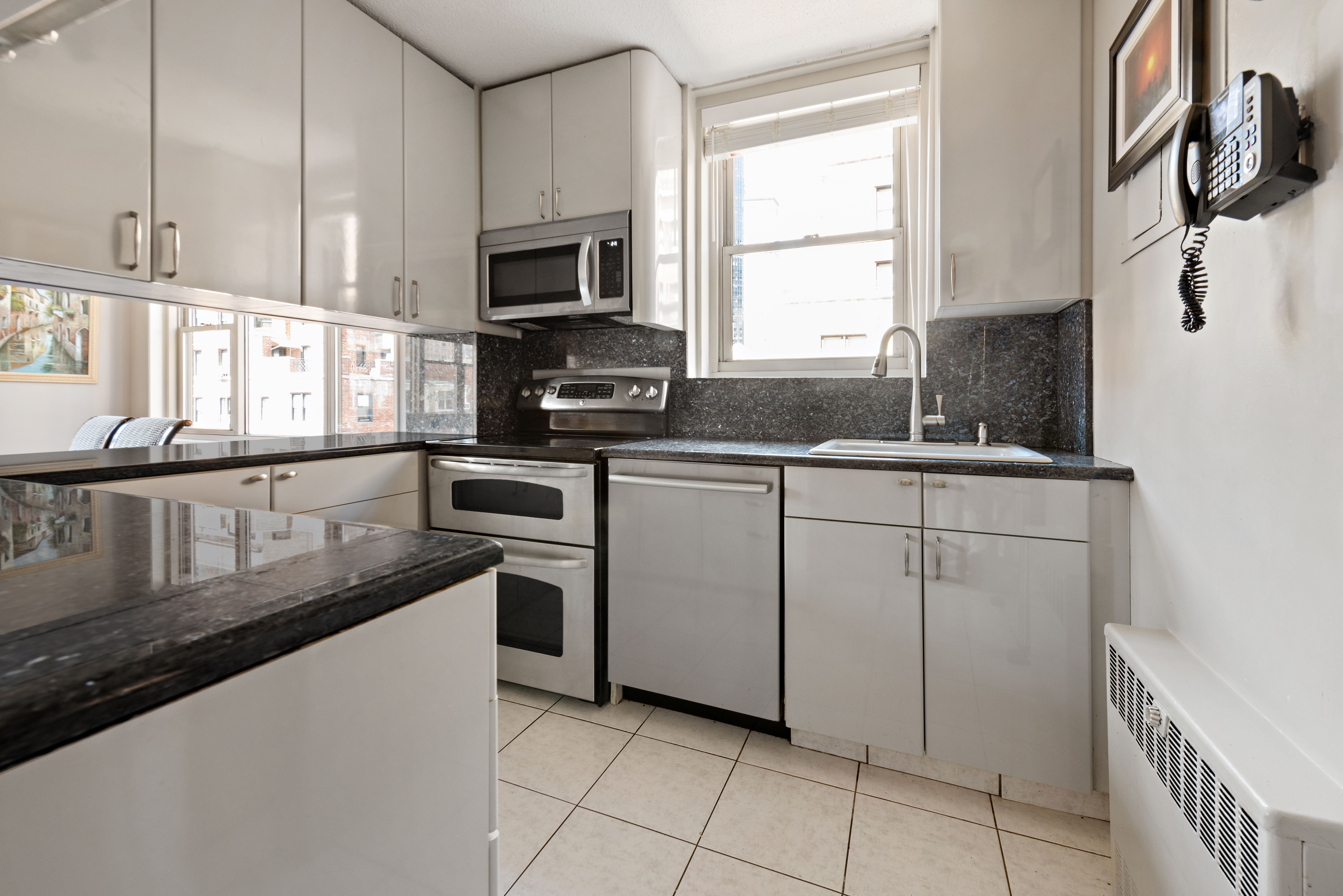 137 East 36th Street, Unit 12G Manhattan, NY 10016 - Photo 5 of 15 a kitchen with stainless steel appliances granite countertop a sink and a stove